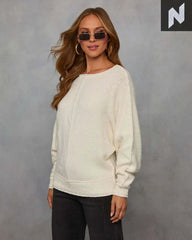 Woman in sunglasses wearing a cozy Avena Knit Sweater with pintuck detailing and relaxed fit on a neutral background.