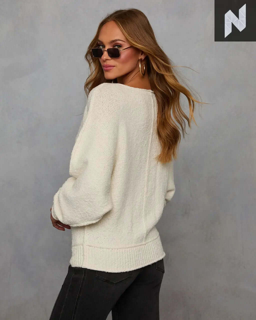 Avena Knit Sweater in cream with cozy knit fabric, featuring ribbed cuffs, styled with sunglasses and casual pants.